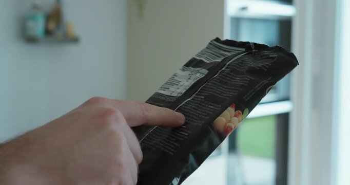 Close-up of a hand pointing at the ingredient list on packaged food, emphasizing allergen awareness, lactose intolerance, and informed consumer choices for safe nutrition.