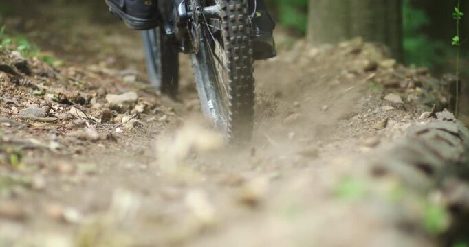 Close Up of Mountain Bike Rear Wheel Braking and Skidding on Forest Trail, Extreme Action Shot of MTB Tire Locking Up on Dirt Path with Flying Dust and Debris, Intense Downhill Cycling