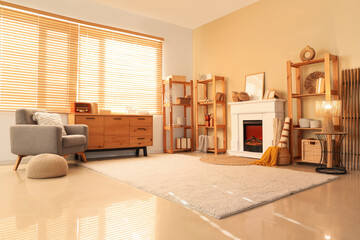 Naklejka premium Interior of cozy living room with fireplace, armchair and shelving units