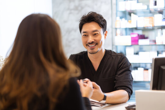 esthetician consulting male client about pore care routine, beauty clinic reception area, bright neutral lighting, professional friendly atmosphere