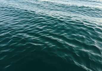 Obraz premium Ripples on the surface of dark blue ocean water under sunlight