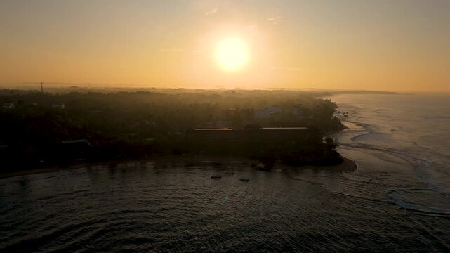 4K aerial silhouette of a tall high-rise building standing in heavy morning smog and golden sunrise