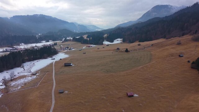 Aerial winter scenery of Wagenbruchsee Geroldsee in Kruen Bavaria. Snowy mountain lake view with the Estergebirge backdrop. A top destination for winter travel in Germany.
