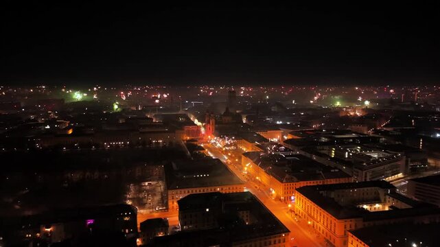 Aerial video of fireworks over Munich old town at night. City lights, historic landmarks and urban celebration atmosphere, also showing environmental impact, noise exposure and wildlife disturbance
