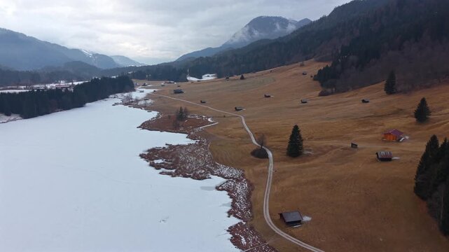 Blick von oben auf den verschneiten Geroldsee Wagenbruechsee. Top-Touristenziel in der Gemeinde Kruen Oberbayern. Winterlandschaft mit Bergen und gefrorenem Alpensee.