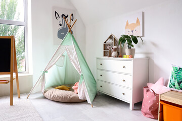 Interior of light playroom with toys, teepee and chalkboard in kindergarten © Pixel-Shot