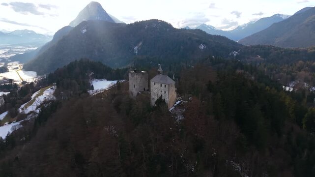 Drohnenvideo von Burg Thierberg zwischen Kiefersfelden und Kufstein. Verschneite Burgruine als beliebter Aussichtspunkt ueber Inn Valley und alpine Berglandschaft.