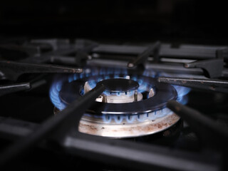 An over hob gas ring burning with a blue flame. Natural resources and energy use concept.
