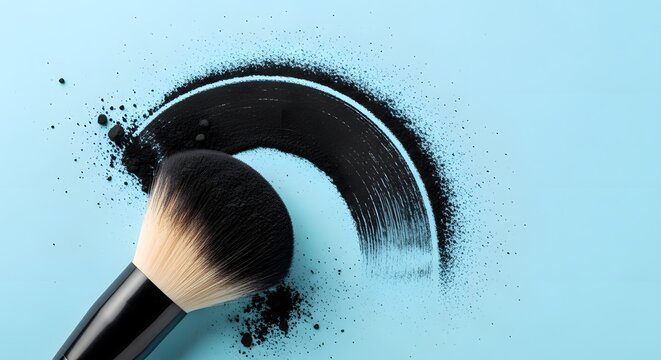 Makeup brush applying black eyeshadow on light blue background for eye makeup tutorial or cosmetics advertisement