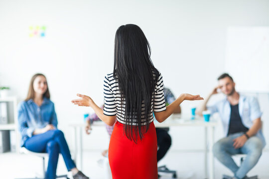 Rear view of woman business coach gesturing with hand