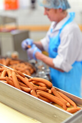 Production of sausages on a conveyor belt in a large meat processing plant - Industrial food...