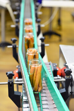 Production of sausages on a conveyor belt in a large meat processing plant - Industrial food processing - Workers in work clothes