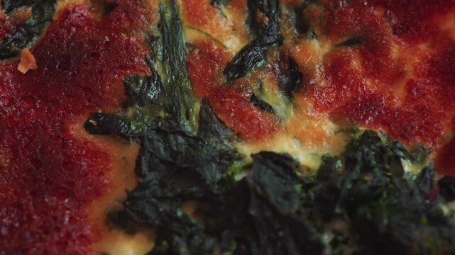 Close up texture of baked spinach quiche surface with melted cheese and browned top, detailed food background showing crispy crust and creamy egg mixture