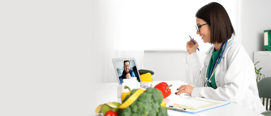 Female nutritionist video chatting with patient at table in office