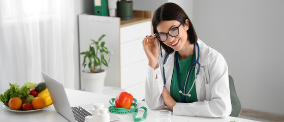 Female nutritionist with stethoscope at table in office