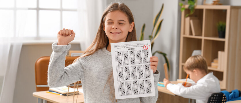 Happy schoolgirl with results of test in classroom