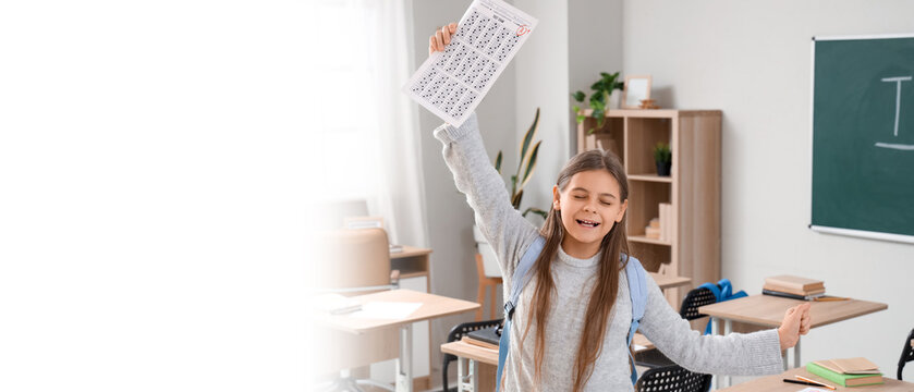 Happy schoolgirl with results of test in classroom