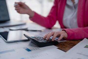 Fototapeta premium Professional woman crunching numbers on a calculator, analyzing financial reports, and managing business accounts, representing accuracy and efficiency in economic planning