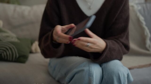 Handheld shot of cheerful adult Caucasian lady demonstrating contraceptive pills and smartphone screen with menstruation calendar while communicating indoors