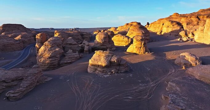 Aerial drone view of Yardang geological landforms in the Gobi Desert, Xinjiang, China, at sunset during golden hour.