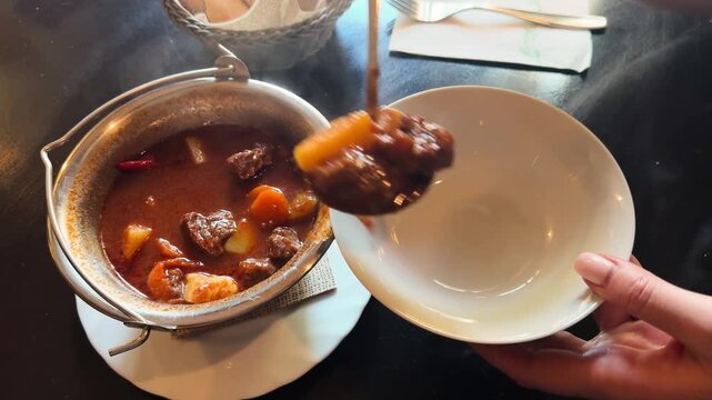 Hungarian Cuisine Concept. Traditional goulash meat soup close up.