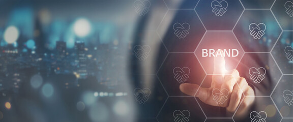 Obraz premium Brand trust and loyalty concept. Touching a glowing Brand icon within a digital network filled with handshake icons, representing trust, credibility, partnerships and strong brand relationships.