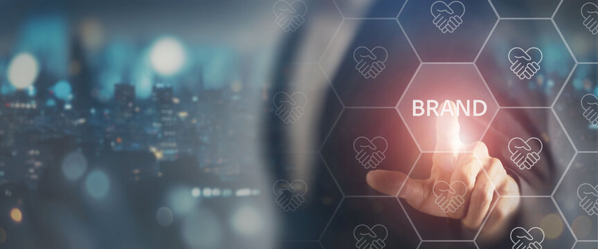 Brand trust and loyalty concept. Touching a glowing Brand icon within a digital network filled with handshake icons, representing trust, credibility, partnerships and strong brand relationships.