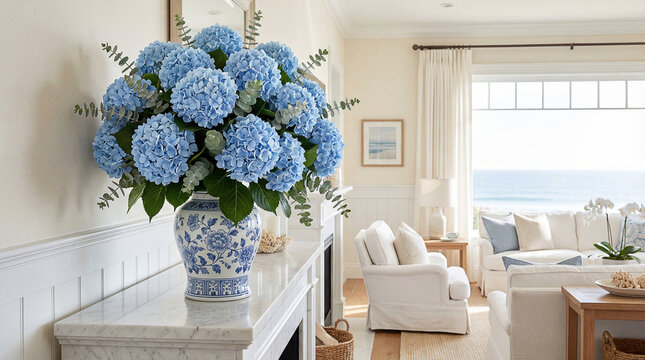 Vibrant sky-blue Hydrangeas and Eucalyptus in a white ginger jar on a marble mantelpiece.