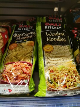 Saujon, France - January 24, 2026: Intermarche. Bali Kitchen brand noodle packages featuring Mie Goreng and Wonton noodles on a supermarket shelf in a grocery store