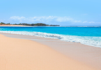 Empty tropical sandy beach and clear sea background with traditional balinese boats at amazing sunset - Bali, Indonesia