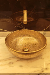 Close up  gold bowl sinks on a white marble vanity in a luxury bathroom