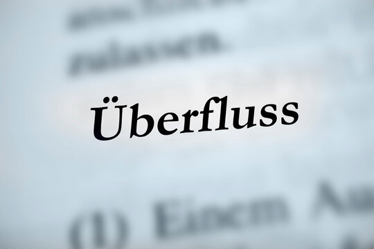 &Uuml;berfluss - deutsches Textwort auf bl&auml;ulichem Hintergrund