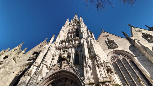 Orbit shot of Saint Maurice Church in Lille, showcasing Gothic facade and historic stone detail under clear blue sky.