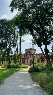Traku Voke manor in Vilnius, Lithuania. Historic manor set amidst a lush park, featuring a grand, symmetrical neoclassical facade with tall columns and ornate, arched windows. 