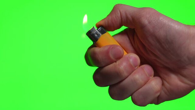 A smoker holds a yellow lighter in his hand.
A person lights a lighter against an isolated background.