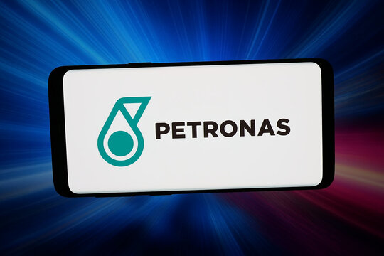 Stuttgart, Germany - 02-27-2026: In this photo illustration, the logo of company Petroliam Nasional Berhad (PETRONAS) is displayed on a smartphone in front of abstract background on computer screen.