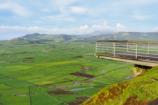 Cloudy sky, Achada Plain valley, agricultural fields and pastures, mountainous landscape and volcanic craters, viewpoint Serra do Cume with the bridge. Terceira Island, Azores, Portugal.