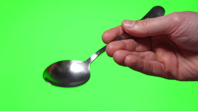 A tablespoon in a man's hand on an isolated background.
Eating spoon