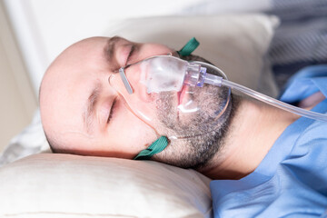 male patient in bed with oxygen mask, Human-centered health support, respiratory support, clinical ventilation interface obstructive sleep apnea treatment, medical breathing equipment in hospital