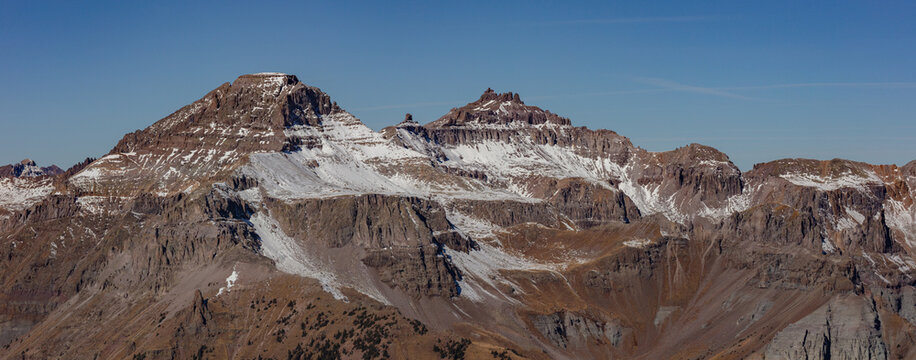 This scenic autumn mountain panorama features Colorado 13ers Potosi Peak and Teakettle Mountain with a dusting of snow. These peaks are located in the San Juan Mountains near Ouray, Colorado.