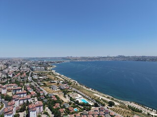 Fototapeta premium Aerial Panoramic View of Coastal Residential Neighborhood and Blue Sea Horizon
