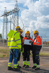 Engineers working on site in electricity substation. Technician wearing safety helmets inspecting...
