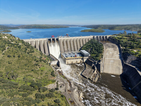 Aerial view of the Alcantara Dam where the powerful Tagus River cascades down, creating a mesmerizing contrast against the rugged landscape, Alcantara, Extremadura, Spain.