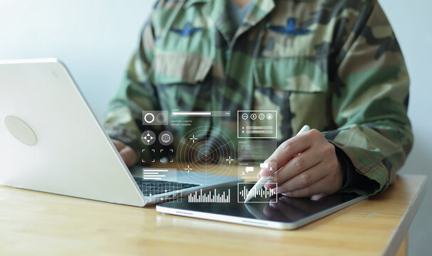soldier man use stylus pencil to check program of radar and radio aviation for test system of tracking and defense at the dark control room center in monitor station for military technology concept