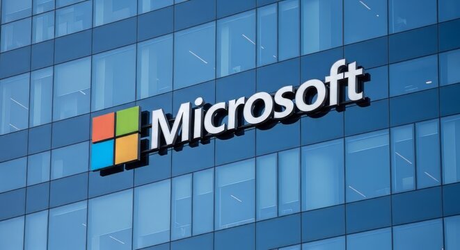 The Microsoft logo is prominently displayed on the side of a modern glass office building with a blue tint