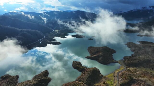 Aerial drone cinematic video of amazing artificial lake Aoou with beautiful nature and reflecting clouds near picturesque village of Metsovo surrounded by mountains of Pindus, Epirus, Greece