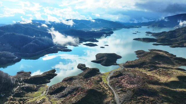 Aerial drone cinematic video of amazing artificial lake Aoou with beautiful nature and reflecting clouds near picturesque village of Metsovo surrounded by mountains of Pindus, Epirus, Greece