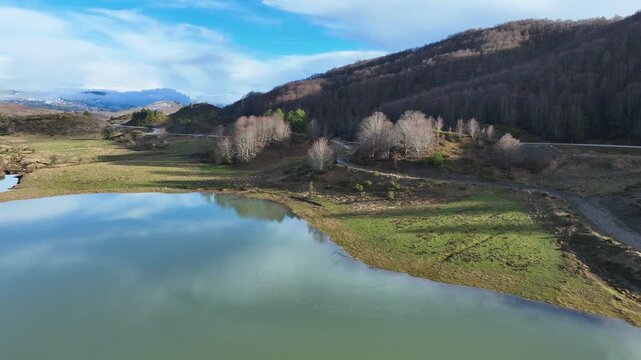 Aerial drone cinematic video of amazing artificial lake Aoou with beautiful nature and reflecting clouds near picturesque village of Metsovo surrounded by mountains of Pindus, Epirus, Greece