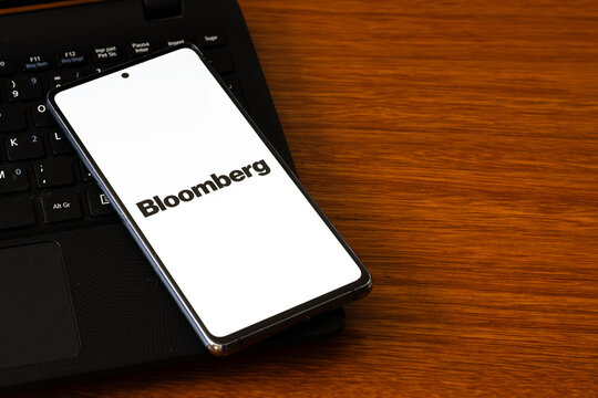 Punta Arenas, Chile &ndash; March 05, 2026: A smartphone screen displaying the black Bloomberg wordmark logo, resting on a black laptop keyboard over a wooden desk