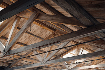 The interior of a rustic wooden building with exposed beams and rafters